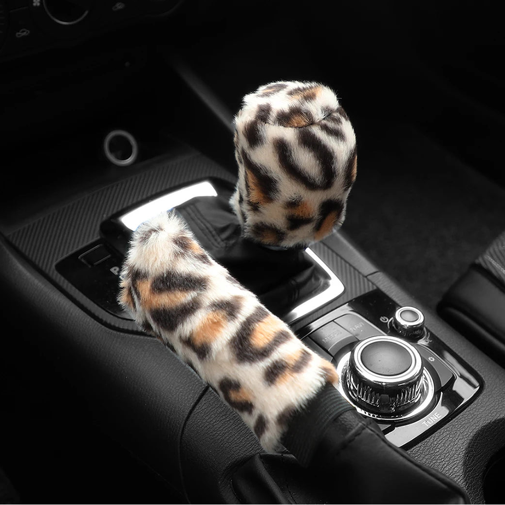 Car handbrake and gear shift cover set with leopard print design on a black car interior.